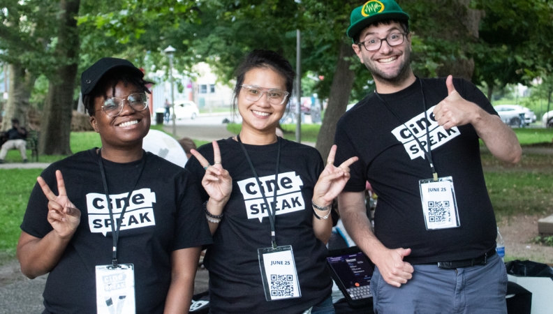 Three people posing; two giving peace signs, one giving a thumbs up