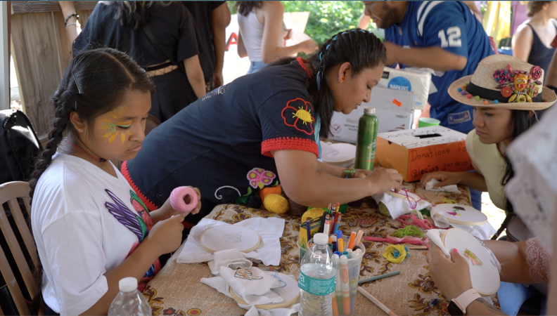 People doing needlepoint projects around a table