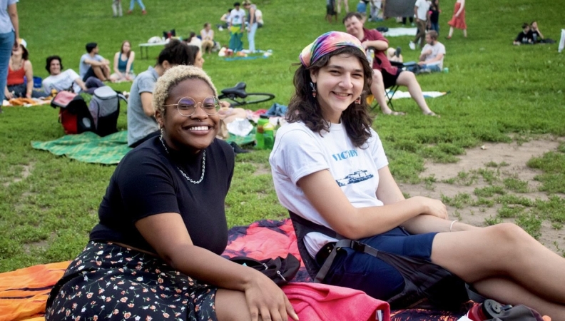 Two people posing on a blanket at a picnic