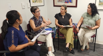 a group of women sit together in a corner having a conversation