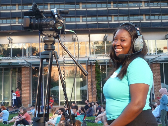 a woman smiling while operating a camera outside at the Constitution Center Mall
