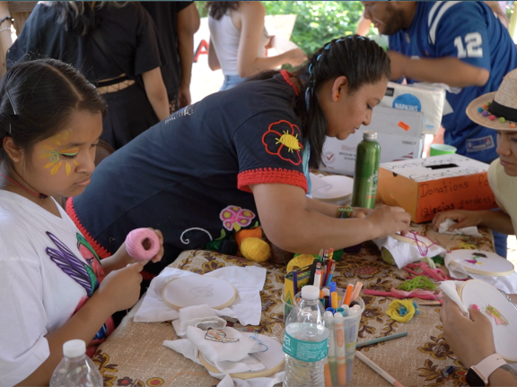 People doing needlepoint projects around a table