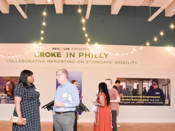 two people chatting at a journalism project exhibit