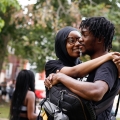 a woman hugging a man while the man carries a backpack