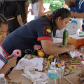 People doing needlepoint projects around a table