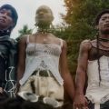Four people standing closely together holding hands