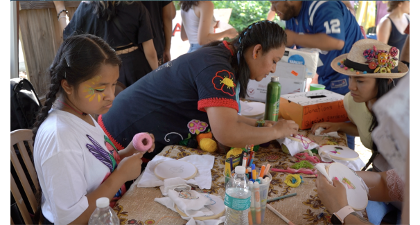 People doing needlepoint projects around a table