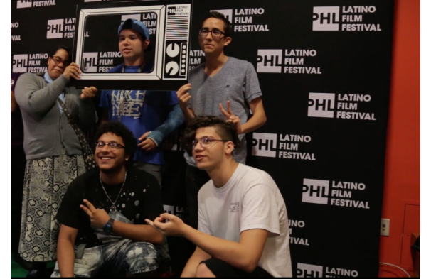 a group of people taking a photo in front of a backdrop that reads PHL Latino Film Festival