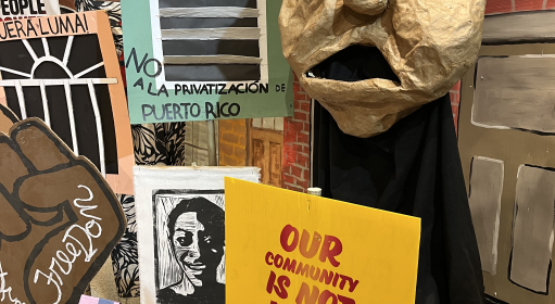A Spiral Q puppet show display that reads 'our community is not for sale'