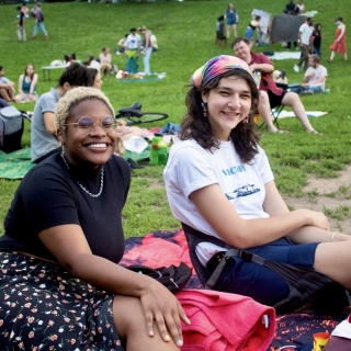 Two people posing on a blanket at a picnic